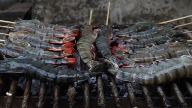 Karides kömür dolu bir tankta çelik ızgarada kızartılır..