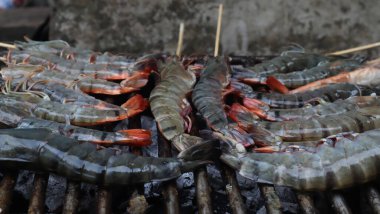 Karides kömür dolu bir tankta çelik ızgarada kızartılır..