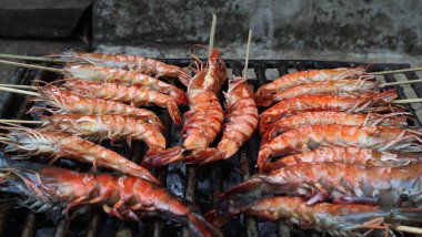 Karides kömür dolu bir tankta çelik ızgarada kızartılır..