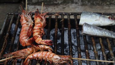 Karides kömür dolu bir tankta çelik ızgarada kızartılır..