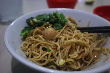 Asyalı kız evde erişte yemekten zevk alıyor. Lezzetli yemek..