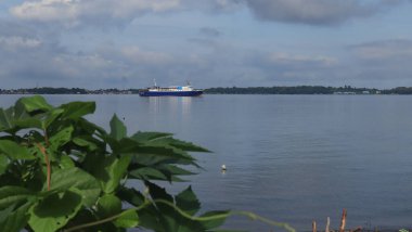 Sahilden deniz manzarası, uzaklardan görünen gemiler ve adalar.