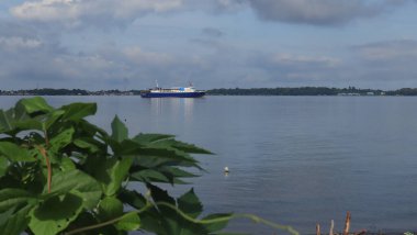 Sahilden deniz manzarası, uzaklardan görünen gemiler ve adalar.