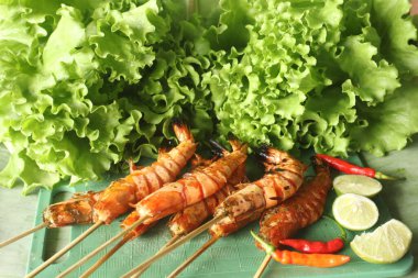 Izgara karides ve marul yaprağının yakın plan portresi.