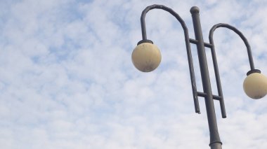 Güneşli havada mavi gökyüzünde elektrik ışıkları. Sokak lambaları