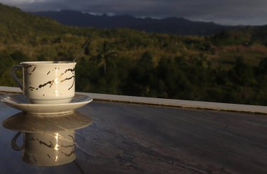 Dağ manzarası arka planında boş kahve fincanı. Kahve içerken iyi şanslar.