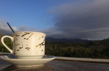 Dağ manzarası arka planında boş kahve fincanı. Kahve içerken iyi şanslar.