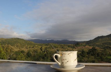 Dağ manzarası arka planında boş kahve fincanı. Kahve içerken iyi şanslar.