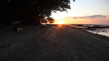 Endonezya 'da okyanus üzerinde dramatik bulutlarda düşük turuncu gün batımı