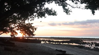 Endonezya 'da okyanus üzerinde dramatik bulutlarda düşük turuncu gün batımı