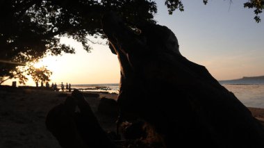 Endonezya 'da okyanus üzerinde dramatik bulutlarda düşük turuncu gün batımı