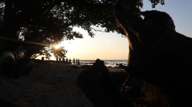 Endonezya 'da okyanus üzerinde dramatik bulutlarda düşük turuncu gün batımı