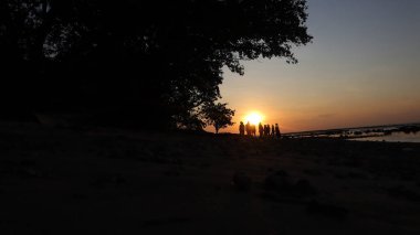 Endonezya 'da okyanus üzerinde dramatik bulutlarda düşük turuncu gün batımı