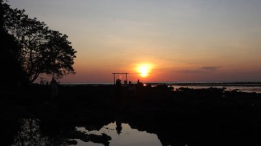 Endonezya 'da okyanus üzerinde dramatik bulutlarda düşük turuncu gün batımı