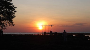 Endonezya 'da okyanus üzerinde dramatik bulutlarda düşük turuncu gün batımı