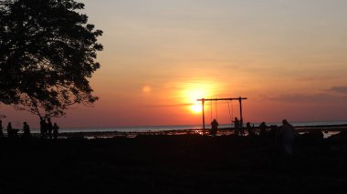 Endonezya 'da okyanus üzerinde dramatik bulutlarda düşük turuncu gün batımı