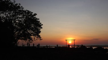 Endonezya 'da okyanus üzerinde dramatik bulutlarda düşük turuncu gün batımı
