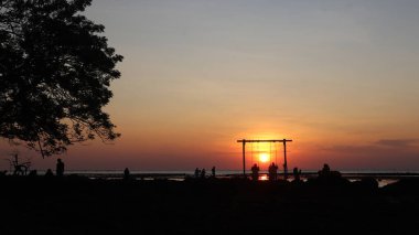 Endonezya 'da okyanus üzerinde dramatik bulutlarda düşük turuncu gün batımı