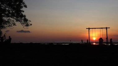 Endonezya 'da okyanus üzerinde dramatik bulutlarda düşük turuncu gün batımı