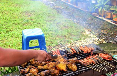 Masanın üzerine acı biber serpiştirilmiş lezzetli ızgara balık servis edilir.