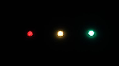 Elektrik panelindeki ışıklar, kırmızı, sarı ve yeşil. Siyah arkaplan.