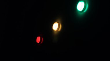 Elektrik panelindeki ışıklar, kırmızı, sarı ve yeşil. Siyah arkaplan.