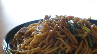 Ahşap masada servis edilen kızarmış erişteler.