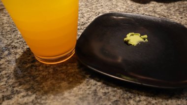 Green wasabi sauce or paste in bowl on wooden background top view