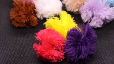 Siyah bir arka planda sıralanmış renkli toplar. Yün yumağı. Eğlence ve neşe kavramı