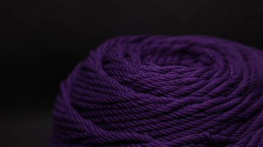 Siyah arka planda turuncu renkli bir iplik yumağı.