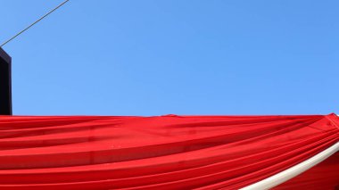 Kırmızı bayrak mavi gökyüzünün bir kısmını kaplıyor.