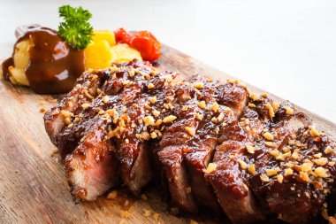 Domatesli ızgara domuz eti, ananas ve ahşap tabakta patates püresi..