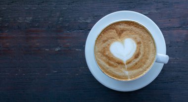 Yüksek açılı kapuçino manzaralı, aşk dolu kalp şekilli sanat eseri..