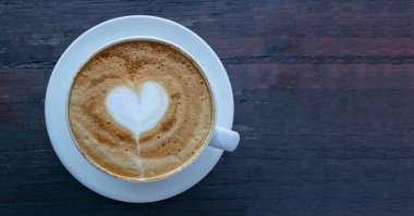 Yüksek açılı kapuçino manzaralı, aşk dolu kalp şekilli sanat eseri..