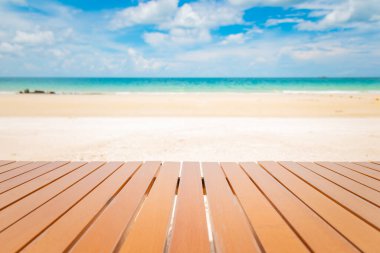 Tropik plajdaki ahşap masanın seçici odak noktası