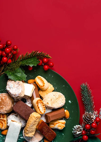 照片的顶部 是红底盘上挂着圣诞装饰品的努加特圣诞甜甜的马屁精和杂碎 西班牙典型的圣诞糖果的配售 — 图库照片