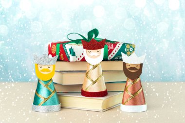 Kitapları, kar taneleri ve mavi arka planda noel ışıkları olan üç bilge adam. Reyes Magos Günü için Üç Bilge Adam