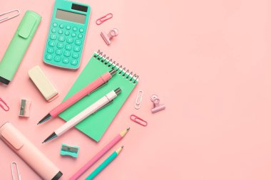 Pembe arkaplandaki mesajlar için fotokopi alanı olan okul malzemelerinin üst görüntüsü. Okul konseptine dönelim.