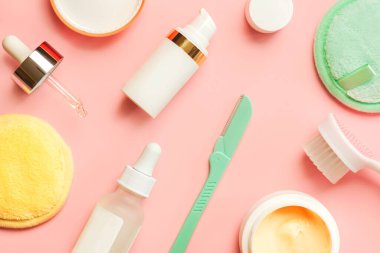 Cilt bakımı ve güzellik için kozmetik ürünleri, yeniden kullanılabilir pamuk makyaj çıkarıcı renkli pedler, yüz temizleme fırçası ve cilt temizleme aracı pembe arka planda. Cilt bakım ürünleri ve güzellik konsepti