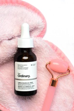 Sıradan cilt bakımı damgası. Sıradan kafein çözeltisi serumunun ve beyaz arka plan üzerinde cilt bakımı için yeşim massan silindirinin kapanışı.