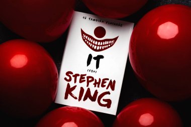 Kitabın İspanyolca yakın plan çekimleri Amerikalı romancı Stephen King ve grunge arkaplanda kırmızı balonlar