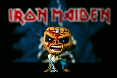 Iron Maiden posterinin önündeki İngiliz heavy metal grubu Iron Maiden 'dan Eddie Mascot' un pop pop figürü. Funko Pop aksiyon figürünün illüstrasyon editörü