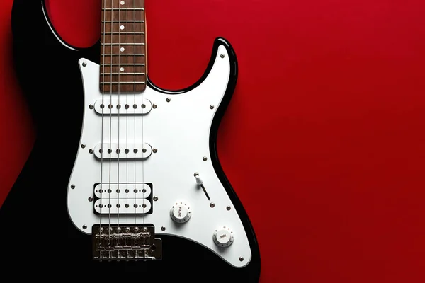 Close-up on electric guitar with space for text over red background