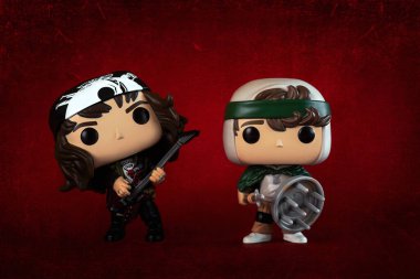 Funko POP vinyl figures of Eddie Munson and Dustin Henderson characters of the TV series Stranger Things over red background. Illustrative editorial of Funko Pop action figures clipart