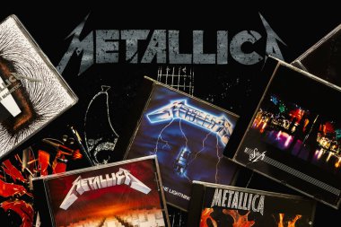 Metallica logosu olan bir tişörtün üzerinde Amerikan heavy metal grubu Metallica 'nın CD' leri var. İllüstrasyon Editörü