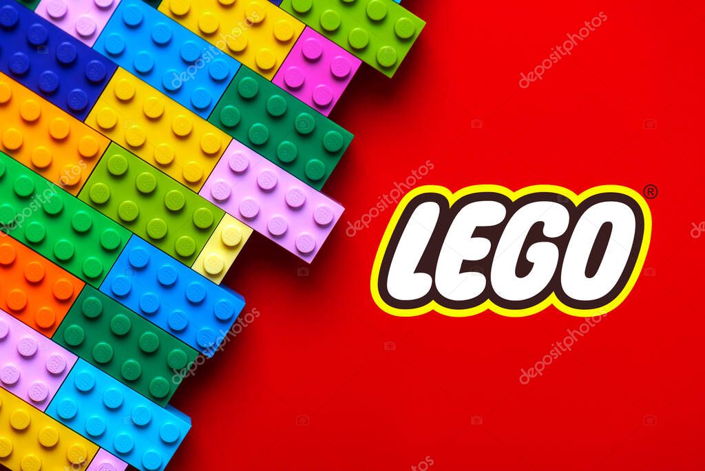 Close up of colorful Lego blocks with the Lego logo over red background. Illustrative editorial