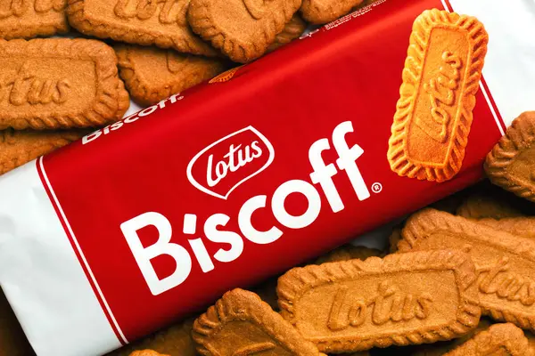 stock image Close up of Lotus branded Biscoff snack pack of Belgian biscuits along with loose cookies. Illustrative editorial