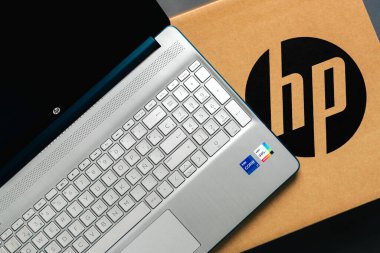 Karton kutunun üstünde Gri arkaplanda HP logosu olan dizüstü bilgisayar HP. İllüstrasyon Editörü