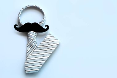 Babalar Günün kutlu olsun. Mavi arkaplan üzerindeki metin için kopya alanı olan kravatın ve takma bıyığın üst görünümü