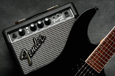 Ses yükselticisi Fender Frontman 10G ve siyah arka planda siyah elektro gitar. İllüstrasyon Editörü
